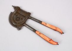 A 19TH CENTURY INDIAN STAINED IVORY HANDLED BEETLE NUT CRACKER, 17cm.