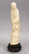 A 19TH CENTURY CHINESE CARVED IVORY FIGURE OF SHOU LAO, stoo holding twin fish upon a rope, 24cm.