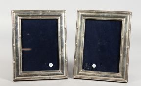 A PAIR OF SILVER UPRIGHT PHOTOGRAPH FRAMES with reeded sides. 7ins x 5ins.
