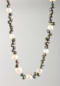 A BLACK & WHITE PEARL NECKLACE with gold fastener.