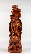 A CHINESE CARVED WOOD FIGURE OF GUANYIN on a lotus base. 20.5ins high.