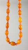 A CORAL AND BUTTERSCOTCH AMBER NECKLACE with gold fastener.