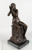 A BRONZE FIGURE OF A SEATED FEMALE NUDE, seated on a rock, her hands held to her mouth, calling out,