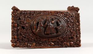 A SUPERB COQUILLA NUT BOX, the top carved with figures. 4.5ins long.