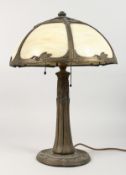 AN ART NOUVEAU STYLE CAST METAL TABLE LAMP, with ornate opaque glass shade, supported on a