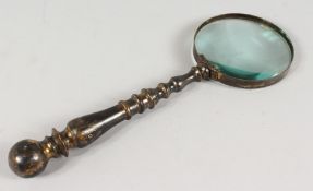 AN OLD BRASS HANDLED MAGNIFYING GLASS.