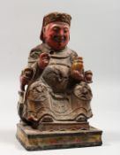 A CHINESE CARVED AND PAINTED WOOD SEATED FIGURE. 9ins high.