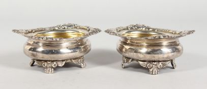 A PAIR OF GEORGE III HEAVY SALTS with cast border and gilt interior on four claw feet. London 1816.