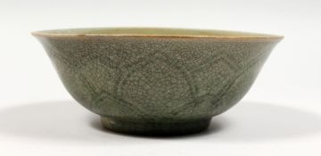 A CHINESE CELADON GLAZED PORCELAIN BOWL with moulded decoration. 7ins diameter.