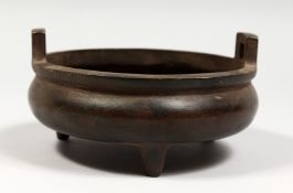 A BRONZE TWIN HANDLED TRIPOD CENSER with Arabic script. 6ins diameter.