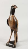 A NAIVE WOODEN CARVED FOLK ART BIRD. 11.5ins high.