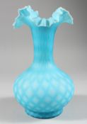 A BLUE OPAQUE GLASS VASE, with frilly edge rim. 9ins high.