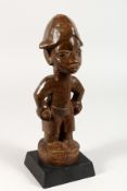 A YORUBA CARVED WOOD TRIBAL FIGURE. 11ins high.