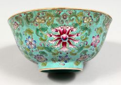 A CHINESE TURQUOISE GLAZED PORCELAIN BOWL, enamel decorated with flowers. 6.5ins.