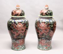 AN IMPRESSIVE PAIR OF FLOOR STANDING CHINESE TEMPLE JARS AND COVERS, black ground decorated with