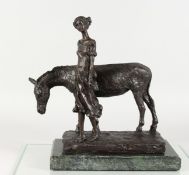 A BRONZE GROUP OF A YOUNG GIRL STANDING BESIDE A DONKEY, mounted on a marble base. 13ins long.