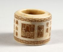 A CHINESE JADE ARCHER'S RING, engraved with calligraphy.