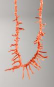 A CORAL NECKLACE with gold clasp.
