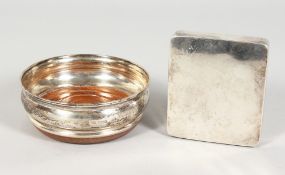 A CIRCULAR WINE COASTER AND A SILVER CIGARETTE BOX.