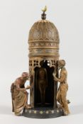 A VIENNA STYLE COLD PAINTED BRONZE GROUP of Arabs standing by a tower. 12ins high.