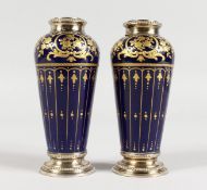 A PAIR OF LIMOGES SMALL PORCELAIN GILT DECORATED BLUE GROUND VASES, with silver mounts. 4.5ins