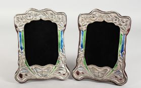 A PAIR OF ART NOUVEAU STYLE SILVER AND ENAMEL PHOTOGRAPH FRAMES. 8.5ins high.