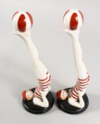 A PAIR OF RED AND WHITE ART DECO STYLE SWIMMERS juggling a ball. 11ins high.