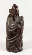 A CHINESE CARVED WOOD FIGURE OF A BEARDED MAN holding a child. 15.5ins high.