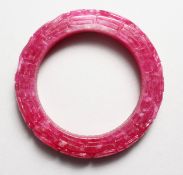 A CHINESE CARVED PINK JADE BANGLE. 3.25ins diameter.