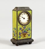 A MINIATURE SILVER CLOCK, with green ground enamel decorated body. 2.5ins high.