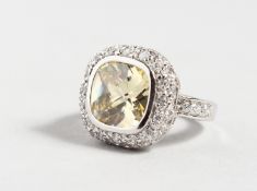 A SILVER RING with yellow coloured stone.