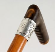 A VICTORIAN WALKING STICK with rhino handle and silver band. 34ins long.