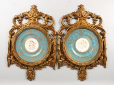 A GOOD PAIR OF SEVRES DESIGN CIRCULAR PLATES in pierced gilt frames, blue and gilt borders,