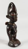 A CARVED WOOD TRIBAL FIGURE with shell necklace. 8ins high.