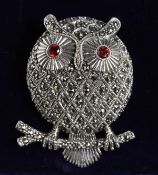 A SILVER AND MARCASITE GARNET EYE OWL BROOCH.