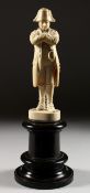 A GOOD CARVED IVORY DIEPPE FIGURE OF NAPOLEON. 7ins high standing on a wooden plinth.