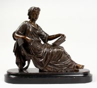 A CLASSICAL BRONZE OF A SEATED YOUNG LADY reading a book, on a wooden base. 10ins long.