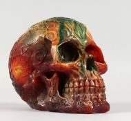 AN AMBER STYLE RESIN MODEL OF A SKULL. 6ins long.