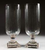 A PAIR OF GLASS STORM LANTERNS, with leaf engraved decoration. 16ins high.