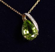A 9CT GOLD PERIDOT PENDANT AND CHAIN.