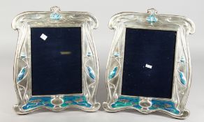 A PAIR OF LARGE SILVER AND ENAMEL UPRIGHT PHOTOGRAPH FRAMES with blue birds. 12.5ins x 10ins.