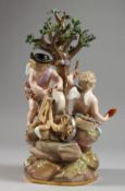 A MEISSEN PORCELAIN GROUP OF THE INFANT CUPID AND PSYCHE beneath a tree, cupid sharpening an
