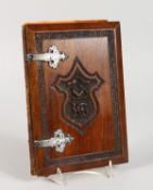 A CARVED WOOD ALBUM with crest and silver hinges, inside are four Victorian stamps.