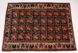 AN UNUSUAL PERSIAN RUG, early 20th Century, possibly Caucasian, the dark blue ground with four