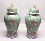 AN IMPRESSIVE PAIR OF FLOOR STANDING CHINESE TEMPLE JARS AND COVERS, green ground decorated with