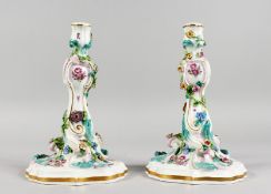A GOOD PAIR OF MEISSEN FLOWER ENCRUSTED CANDLESTICKS with scrolls. Cross swords mark in blue. 9.5ins