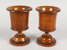 A PAIR OF TURNED TREEN URN SHAPED GOBLETS. 5.75ins high.