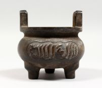 A BRONZE TWIN HANDLED TRIPOD CENSER with Arabic script. 4ins diameter.