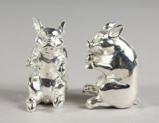 A PAIR OF SEATED PIG SALT AND PEPPERS.