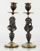 A SMALL PAIR OF PATINATED AND POLISHED BRONZE CANDLESTICKS, the stems cast as bust of young